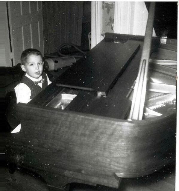 At the piano, age five